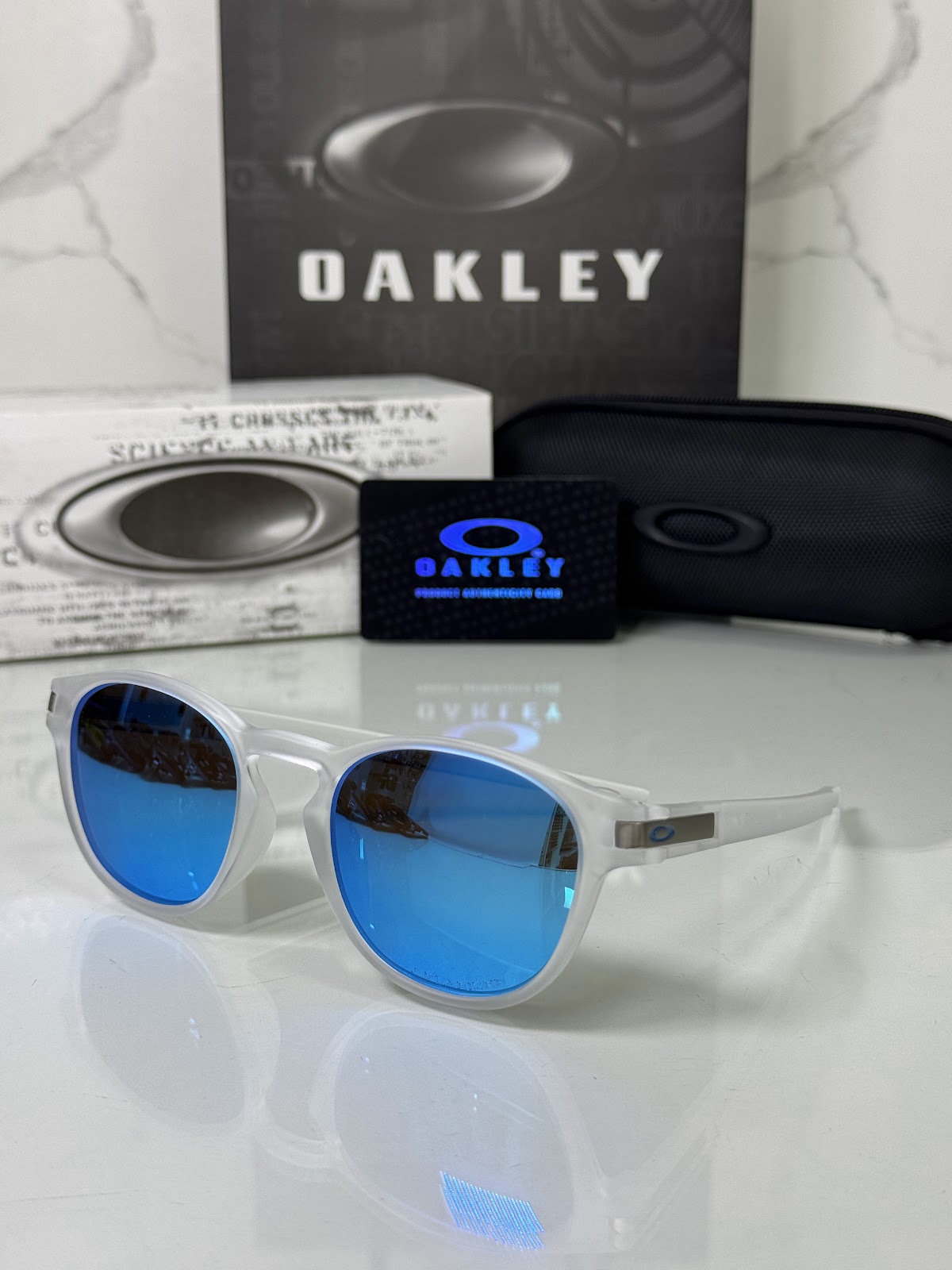 Lentes OAKLEY — Ref. LF-L235-0104 con el packaging mostrado en la fotografía