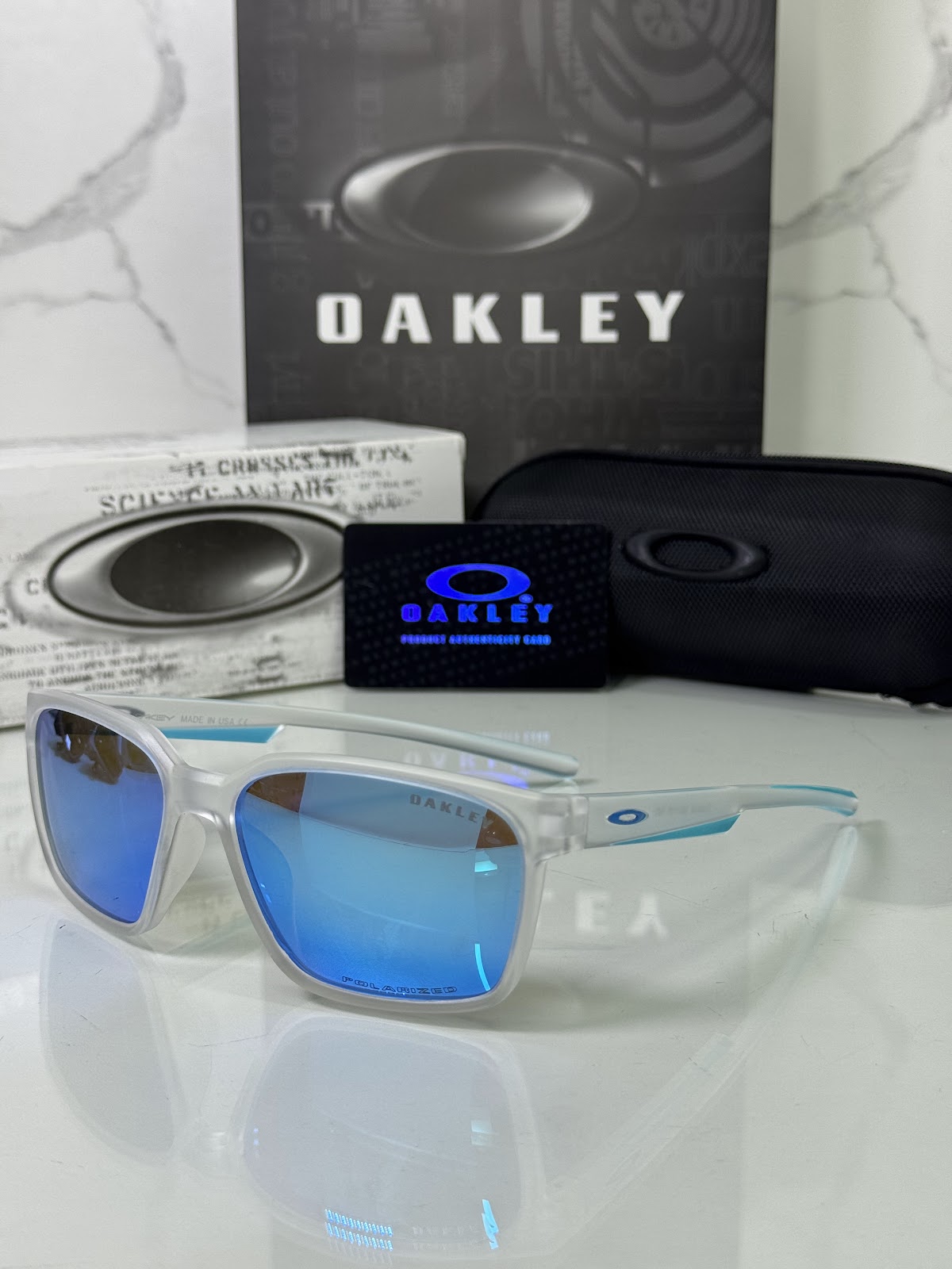 Lentes OAKLEY — Ref. LF-L235-0118 con el packaging mostrado en la fotografía
