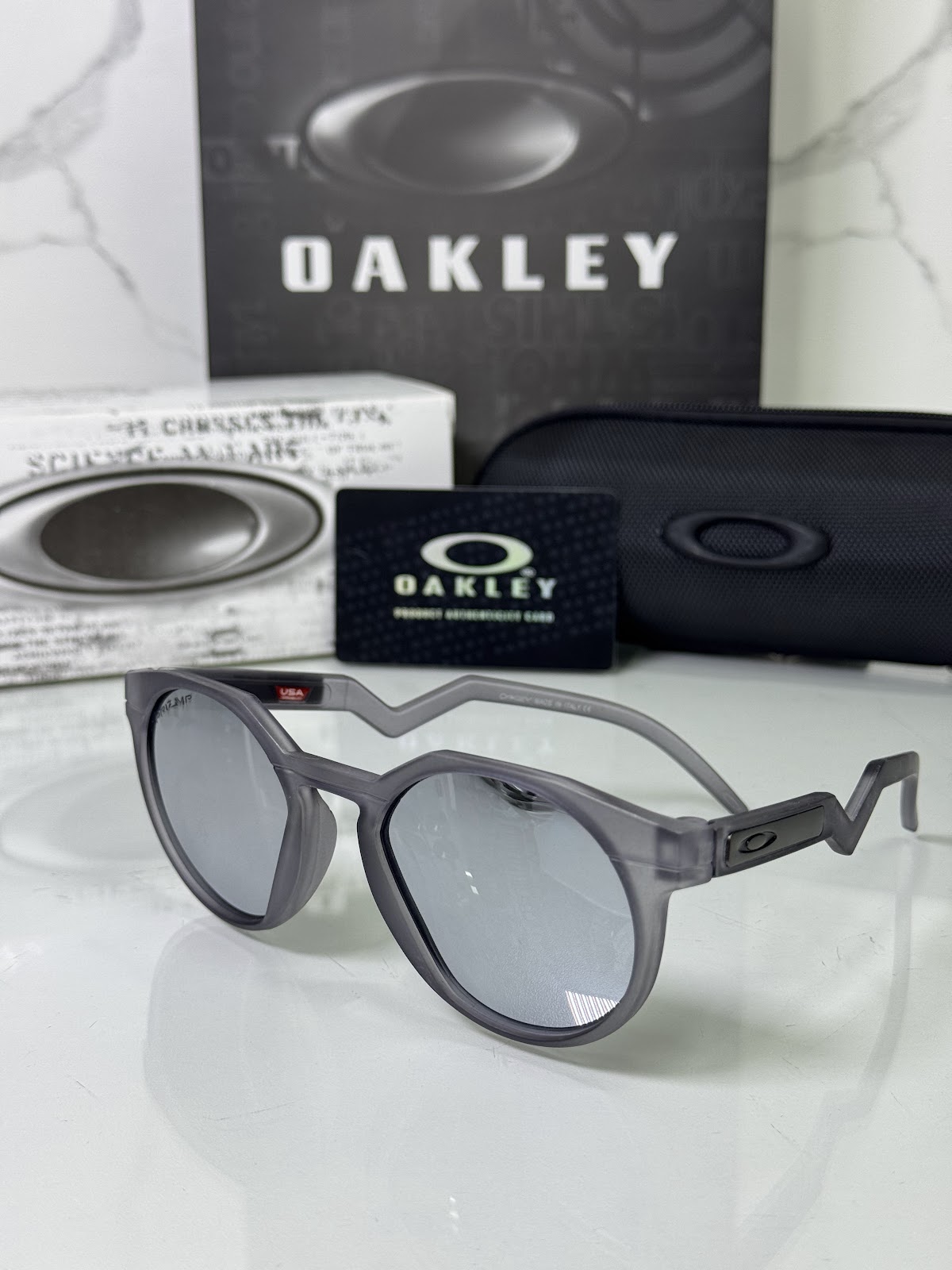 Lentes OAKLEY — Ref. LF-L235-0133 con el packaging mostrado en la fotografía