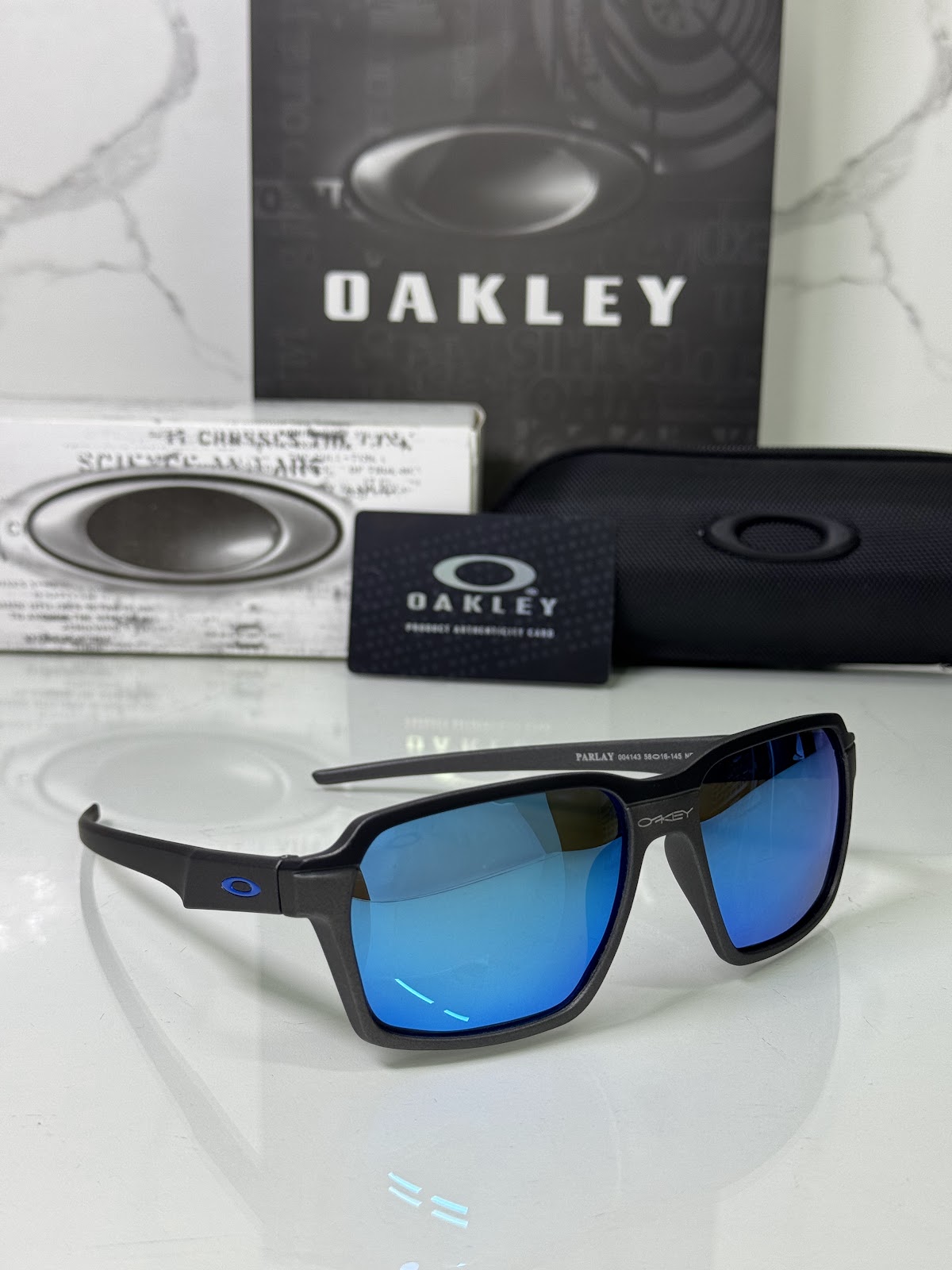 Lentes OAKLEY — Ref. LF-L235-0143 con el packaging mostrado en la fotografía