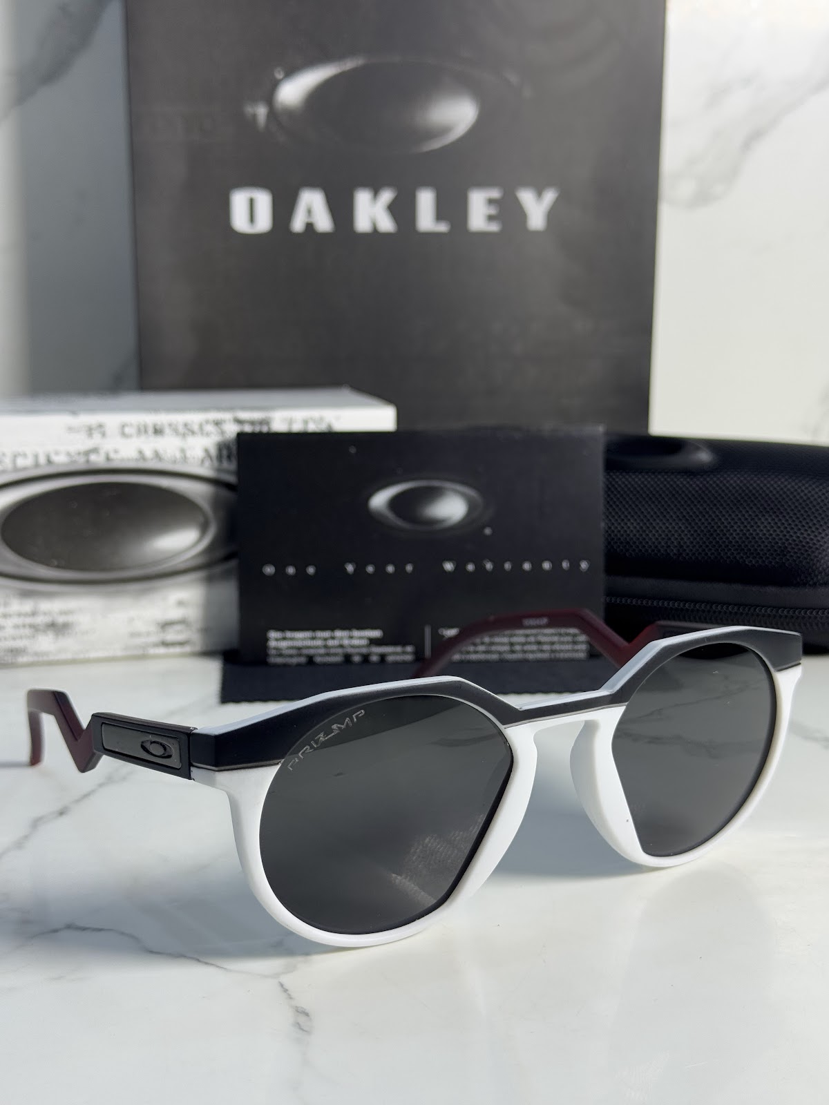 Lentes OAKLEY — Ref. LF-L235-0256 con el packaging mostrado en la fotografía