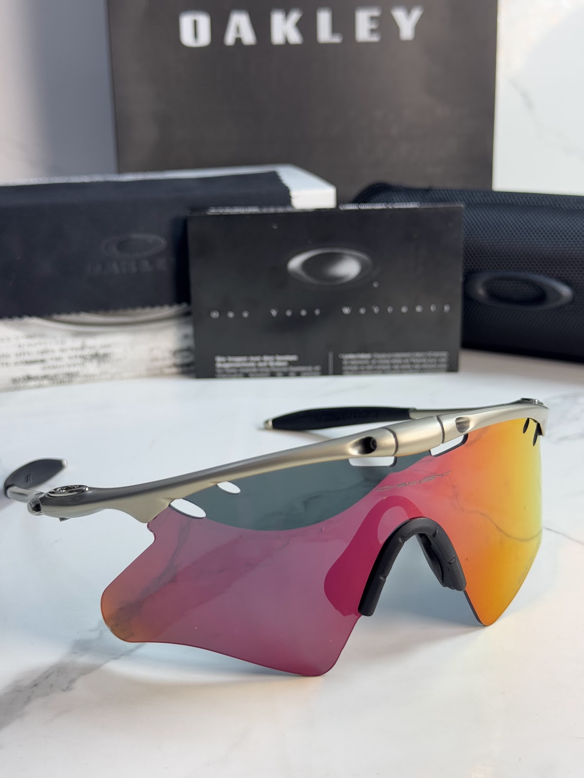 Lentes OAKLEY — Ref. LF-L235-0458 con el packaging mostrado en la fotografía