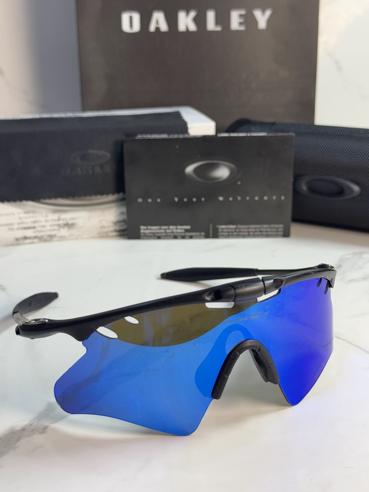 Lentes OAKLEY — Ref. LF-L235-0459 con el packaging mostrado en la fotografía